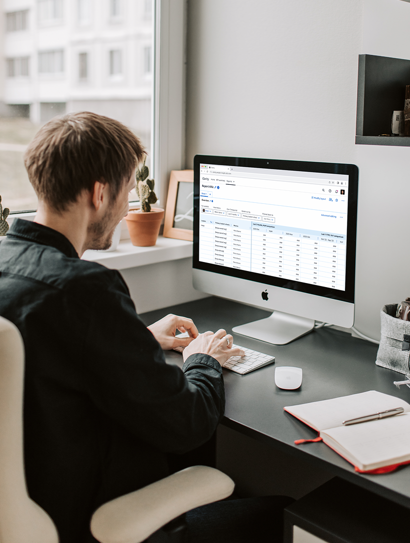 A manager reviewing a Clarity report on an iMac
