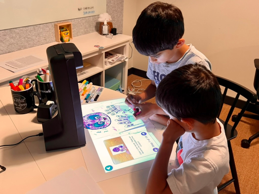Two children playing a projected Glow activity at a table
