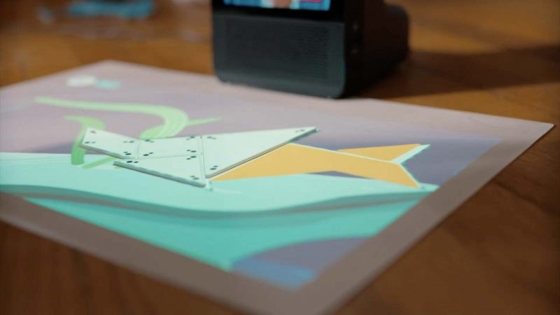 Tangram pieces laid on the projected Glow mat, forming a shape in a pastel scene